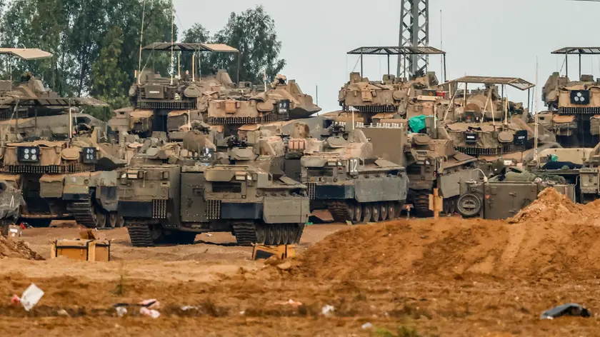 epa10925020 Israeli troops with a variety of military vehicles at a gathering site at an undisclosed location along the Israel-Gaza border, in southern Israel, 18 October 2023. According to Palestinian officials hundreds of people have been killed in an air strike on a hospital in Gaza on 17 October. Hamas blames the blast on an Israeli air strike, but Israel says it was caused by rockets misfired by another group and both sides deny responsibility. EPA/HANNIBAL HANSCHKE