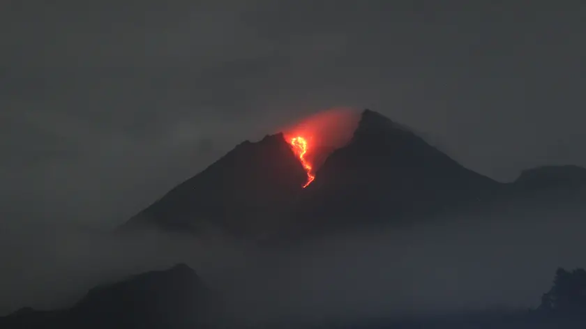 epa09814028 A handout photo made available by the Indonesian Geological Agency shows Mount Merapi spewing volcanic material during an eruption, as seen from Deles village, Klaten, Central Java, Indonesia, 09 March 2022 (issued 10 March 2022). According to the geological agency, Mount Merapi volcano spewed hot clouds as far as five kilometers to the southeast. No casualties were reported. EPA/INDONESIAN GEOLOGICAL AGENCY / HANDOUT HANDOUT EDITORIAL USE ONLY/NO SALES