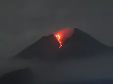 epa09814028 A handout photo made available by the Indonesian Geological Agency shows Mount Merapi spewing volcanic material during an eruption, as seen from Deles village, Klaten, Central Java, Indonesia, 09 March 2022 (issued 10 March 2022). According to the geological agency, Mount Merapi volcano spewed hot clouds as far as five kilometers to the southeast. No casualties were reported. EPA/INDONESIAN GEOLOGICAL AGENCY / HANDOUT HANDOUT EDITORIAL USE ONLY/NO SALES