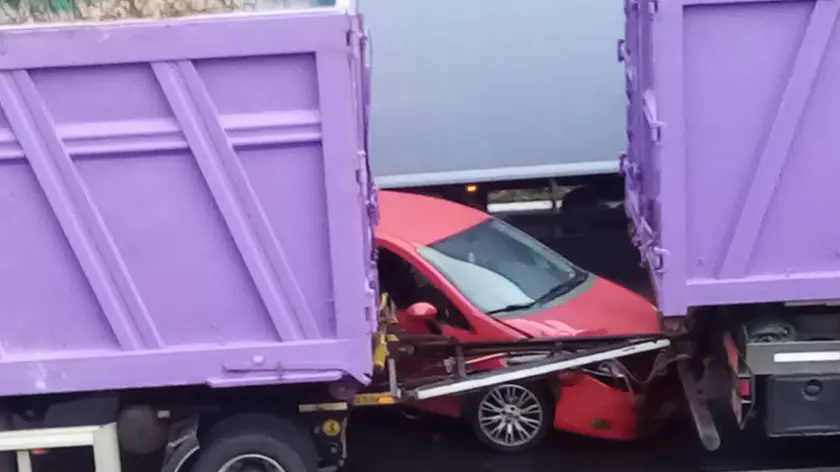 L'auto incastrata tra le due sezioni del rimorchio del camion