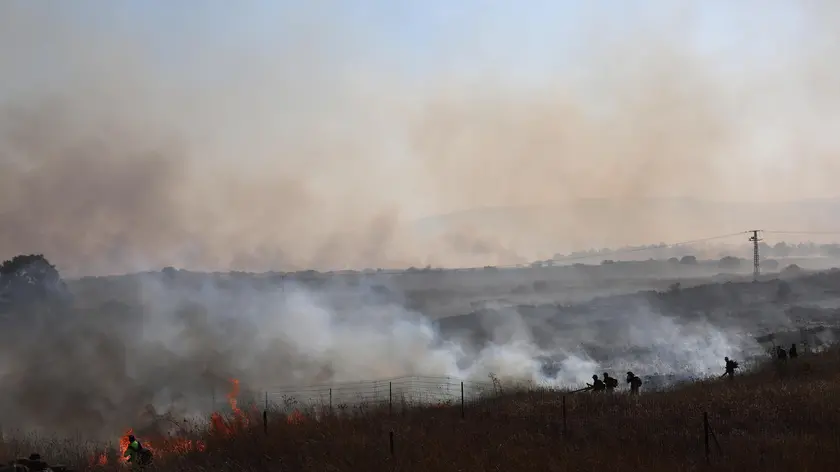 epa11385813 Firefighters work to douse a fire that broke out following projectiles fired from southern Lebanon, near the town of Katzrin in the Golan Heights, next to the Israeli border with Syria, 02 June 2024. The Israeli Army spokesperson reported on 02 June that 15 projectiles were fired from Lebanon toward the area of Katzrin. The projectiles fell in open areas and no injuries were reported. EPA/ATEF SAFADI
