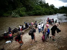 epa10904499 Migrants disembark from canoes to be transferred to an immigration reception station in Lajas Blancas, Meteti, Darien, Panama 06 October 2023.The presidents of Panama, Laurentino Cortizo, and Costa Rica, Rodrigo Chaves, traveled this 06 October to the Darien region, bordering Colombia, to address together the migration crisis, with the daily arrival of thousands of migrants on their way to the United States. EPA/Bienvenido Velasco