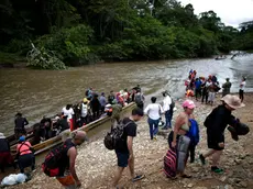 epa10904499 Migrants disembark from canoes to be transferred to an immigration reception station in Lajas Blancas, Meteti, Darien, Panama 06 October 2023.The presidents of Panama, Laurentino Cortizo, and Costa Rica, Rodrigo Chaves, traveled this 06 October to the Darien region, bordering Colombia, to address together the migration crisis, with the daily arrival of thousands of migrants on their way to the United States. EPA/Bienvenido Velasco