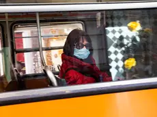 A woman wears a protective face mask aboard of a bus, Milan, Italy, 09 March 2020. ANSA/Marco Ottico