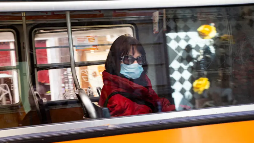 A woman wears a protective face mask aboard of a bus, Milan, Italy, 09 March 2020. ANSA/Marco Ottico