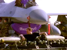 AVI01D:YUGOSLAVIA-KOSOVO-NATO:AVIANO,ITALY,1APR99 - U.S. soldier takes a rest over air bombs while an F16 is repaired behind him at Aviano air base in the North of Italy April 1. Aircrafts from the U.S., Canada, U.K., Spain and Portugal are at Aviano supporting NATO's Operation Allied Force. jr/Photo by Jose Manuel Ribeiro REUTERS