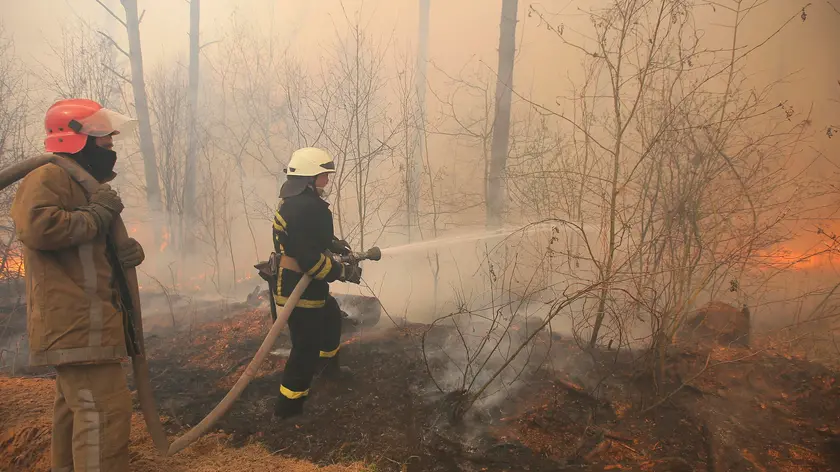 epa08357557 Firefighters battle with a forest fire burns near the village of Ragovka, close to the exclusion zone around the Chernobyl nuclear power plant, Ukraine, 10 April 2020 (issued 11 April 2020). Officials have been fighting fires in the exclusion zone since 04 April 2020. In early April 2020, NASA satellites observed several wildfires in northern Ukraine around the Chornobyl Exclusion Zone as local media report. Hundreds of firefighters and at least eight airborne units were working to extinguish fires in the Denysovets, Kotovsky, and Korogodsky forests, NASA's Earth Observatory reports. The territory is a long-vacated area near where an explosion at the Chernobyl Soviet nuclear plant in April 1986 sent a plume of radioactive fallout high into the air and across swaths of Europe. EPA/STR