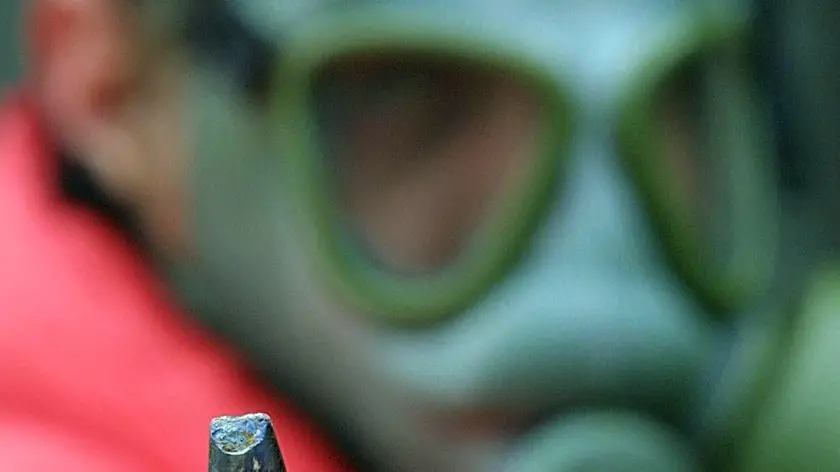 Una immagine d'archivio di un tecnico dell'istituto di studi fisici dell'università di Belgrado che mostra un proiettile ad uranio impoverito da 30 mm come quelli utilizzati in alcuni bombardamenti delle forze Nato in Bosnia e Kosovo