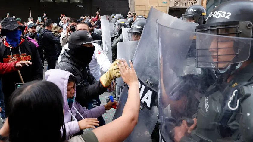epa11138303 People clash with the police during a protest in Bogota, Colombia, 08 February 2024. Gerson Chaverra, the President of the Supreme Court of Justice of Colombia, condemned in harsh terms the "violent and illegal blockade" of protesters supporting the government, as they marched to the Palace of Justice, located in the center of Bogota, an act that he considered "unacceptable". EPA/Mauricio Duenas Castaneda