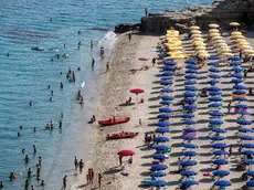 People relax and enjoy a sunny day at the beach, in Tropea, Italy, 25 July 2021. ANSA/ANGELO CARCONI
