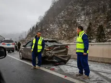 epa11100713 Local security stand guard at a damaged car following an accident caused by slippery roads in Zhenxiong County, Yunnan province southwest of China, 24 January 2024. Local authorities reported at least 31 dead and more than 10 people missing after a landslide hit Liangshui Village in China's southwest province of Yunnan early morning on 22 January. Over 1,000 personnel have been mobilized by the government to help in rescue and evacuation efforts. EPA/MARK R. CRISTINO