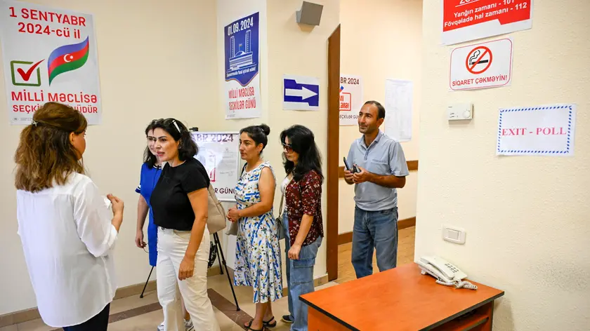epa11576957 People lineup to collect their ballots at a polling station during the parliamentary elections in Baku, Azerbaijan, 01 September 2024. Parliamentary elections are taking place in Azerbaijan on 01 September. 990 candidates are competing for 125 seats in the Milli Mejlis parliament. EPA/ROMAN ISMAYILOV