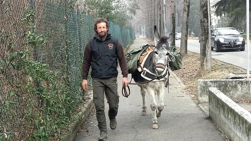 Alfio Scandurra mentre cammina lungo una strada con il suo inseparabile amico a quattro zampe Fiocco