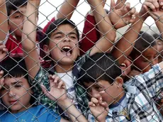 Syrian refugee children stand at a fence after German Chancellor Angela Merkel, EU Council President Donald Tusk and Turkish Prime Minister Ahmet Davutoglu (none pictured) visited the refugee camp in Nizip district near Gaziantep, Turkey, 23 April 2016. Merkel travelled to Turkey with the President of the European Council, Donald Tusk, to get informed about the implementation of the EU-Turkey Refugee Agreement. ANSA/SEDAT SUNA