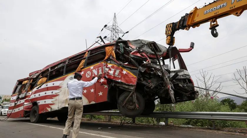 epa05346871 A crane removes a damaged bus from the scene of accident on the Mumbai - Pune expressway near Panvel, on the outskirts of Mumbai, India, 05 June 2016. At least 17 people were killed and more than 35 injured after a bus traveling on an expressway in western India crashed into two cars and fell into a six-meter deep ditch. EPA/DIVYAKANT SOLANKI