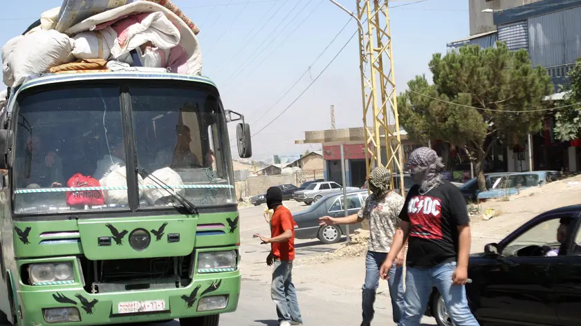 epa03363157 Members of a Lebanese Salafist group inspect a Syrian vehicle at a checkpoint in Majdal Anjar, near the Lebanese-Syrian border, eastern Lebanon, 16 August 2012. A group of masked Sunni youths set up barriers on the main road in Majdal Anjar, reportedly known for protecting Sunni fundamentalist fugitives, to the Lebanon-Syria al-Masnaa border crossing, carrying out ID checks before deciding whether to let them pass. A spokesman for the group, Ali Abdul Khaliq, said their action was in response to the recent kidnappings of Sunnis by Shiites in Beirut. Arab countries, including Saudi Arabia, Kuwait, Qatar and the United Arab Emirates, on 16 August started evacuating their citizens from Lebanon over a series of kidnappings of Sunni Muslim foreigners by a Lebanese Shiite clan demanding the release of one of its members held by Syrian rebels. The kidnappings raised fears that the Syrian conflict was spilling over the border into Lebanon, which is divided along sectarian lines that mirror those in Syria. EPA/LUCIE PARSEGHIAN