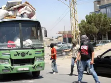 epa03363157 Members of a Lebanese Salafist group inspect a Syrian vehicle at a checkpoint in Majdal Anjar, near the Lebanese-Syrian border, eastern Lebanon, 16 August 2012. A group of masked Sunni youths set up barriers on the main road in Majdal Anjar, reportedly known for protecting Sunni fundamentalist fugitives, to the Lebanon-Syria al-Masnaa border crossing, carrying out ID checks before deciding whether to let them pass. A spokesman for the group, Ali Abdul Khaliq, said their action was in response to the recent kidnappings of Sunnis by Shiites in Beirut. Arab countries, including Saudi Arabia, Kuwait, Qatar and the United Arab Emirates, on 16 August started evacuating their citizens from Lebanon over a series of kidnappings of Sunni Muslim foreigners by a Lebanese Shiite clan demanding the release of one of its members held by Syrian rebels. The kidnappings raised fears that the Syrian conflict was spilling over the border into Lebanon, which is divided along sectarian lines that mirror those in Syria. EPA/LUCIE PARSEGHIAN