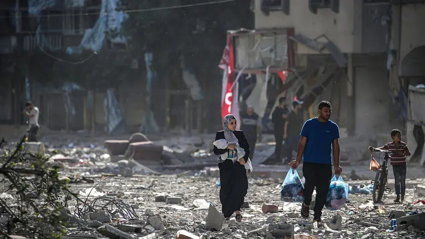epa10948941 Palestinians walk among the rubble after Israeli air strikes on Tel al-Hawa neighborhood, in Gaza City, 30 October 2023. The IDF struck over 600 militant targets over the past few days as it continued to 'expand ground operations' in the Gaza Strip, the Israel Defense Forces (IDF) said on 30 October. More than 8,000 Palestinians and at least 1,400 Israelis have been killed, according to the Israel Defense Forces (IDF) and the Palestinian health authority, since Hamas militants launched an attack against Israel from the Gaza Strip on 07 October, and the Israeli operations in Gaza and the West Bank which followed it. EPA/MOHAMMED SABER