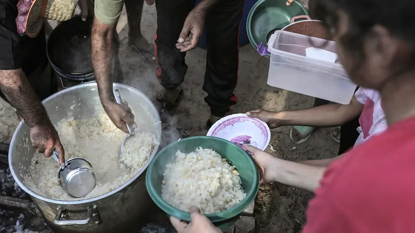 epa10938579 Palestinian volunteers hand food to Palestinians seeking refuge on the grounds of a United Nations Relief and Works Agency for Palestine Refugees (UNRWA) center at the Khan Yunis refugee camp, west of the town of Khan Yunis, southern Gaza Strip, 25 October 2023. More than 5,500 Palestinians and over 1,400 Israelis have been killed, according to the Israel Defense Forces (IDF) and the Palestinian health authority, since Hamas militants launched an attack against Israel from the Gaza Strip on 07 October, and the Israeli operations in Gaza and the West Bank which followed it. EPA/HAITHAM IMAD