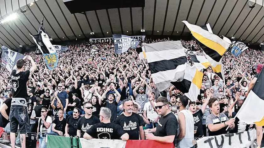 La Curva Nord durante la gara con la Roma e, in alto, lo striscione “Tutti a Verona” sulla recinzione dello stadio © Foto Petrussi