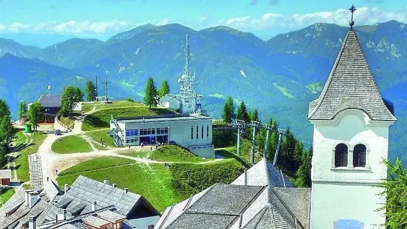 Il monte Lussari; a sinistra, le stazioni d’arrivo delle due cabinovie, tra le quali parte la pista Misconca