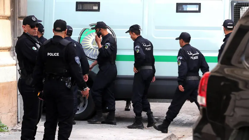 epa08039141 Algerian policemen stand next to a police vehicle carrying the two Algerian former Prime Ministers Abdelmalek Sellal and Ahmed Ouyahia at the Court of Sidi Mhamed of Algiers, Algeria, 02 December 2019. The two former prime ministers under the Bouteflika regime will appear before the judge on charges of money laundering and corruption. EPA/MOHAMED MESSARA