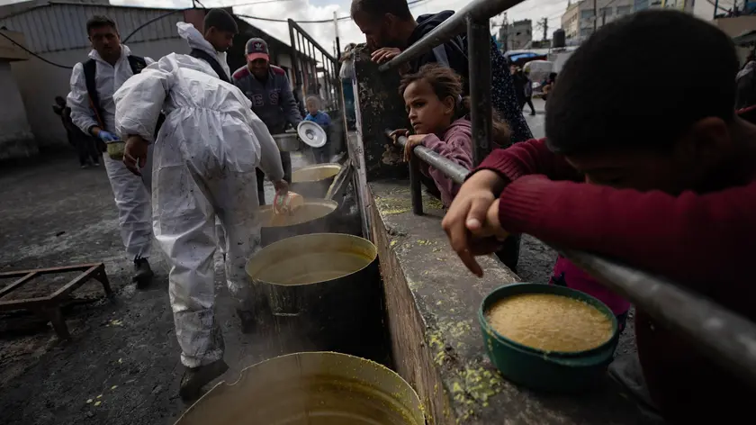 epa11203796 Internally displaced Palestinians hold empty bowls as they line up to receive food aid provided by a Palestinian youth group in the Rafah refugee camp, southern Gaza Strip, 07 March 2024. Since 07 October 2023, up to 1.9 million people, or more than 85 percent of the population, have been displaced throughout the Gaza Strip, some more than once, according to the United Nations Relief and Works Agency for Palestine Refugees in the Near East (UNRWA), which added that most civilians in Gaza are in 'desperate need of humanitarian assistance and protection'. EPA/HAITHAM IMAD