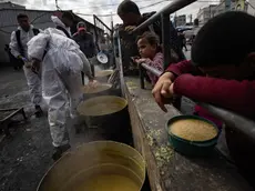 epa11203796 Internally displaced Palestinians hold empty bowls as they line up to receive food aid provided by a Palestinian youth group in the Rafah refugee camp, southern Gaza Strip, 07 March 2024. Since 07 October 2023, up to 1.9 million people, or more than 85 percent of the population, have been displaced throughout the Gaza Strip, some more than once, according to the United Nations Relief and Works Agency for Palestine Refugees in the Near East (UNRWA), which added that most civilians in Gaza are in 'desperate need of humanitarian assistance and protection'. EPA/HAITHAM IMAD