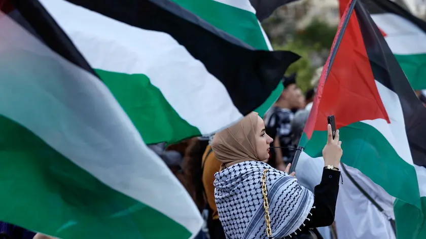 epa11277104 Protesters hold Palestinian flags during a pro-Palestinian rally called by the Palestinian Community and the 'Plataforma Valencia Amb Palestina' platform held at Valencia's City Hall square in Valencia, eastern Spain, 13 April 2024. More than 33,600 Palestinians and over 1,450 Israelis have been killed, according to the Palestinian Health Ministry and the Israel Defense Forces (IDF), since Hamas militants launched an attack against Israel from the Gaza Strip on 07 October 2023, and the Israeli operations in Gaza and the West Bank which followed it. EPA/Kai Foersterling
