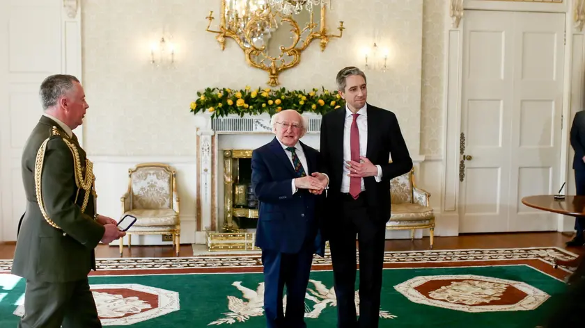 epa11267460 Ireland's President Michael Higgins (C) shakes hands with the newly elected Taoiseach Simon Harris (R) after signing the Warrant of Appointment at Aras an Uachtarain, the official residence of the Irish President, in Dublin, Ireland, 09 April 2024. Harris was elected by the Irish parliament as the 15th Taoiseach, following the surprise resignation of Leo Varadkar and is the country's youngest-ever premier. EPA/MOSTAFA DARWISH