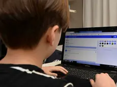 Un giovane studente della Scuola Elementare Renzo Pezzani di Milano svolge alcuni compiti online organizzati dall'insegnante dopo la chiusura delel scuole a causa dell'emergenza coronavirus. Ansa/Andrea Fasani