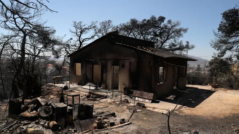 epa11547399 A burnt house after a wildfire in the area of Vrilissia close to Athens city, Greece, 13 August 2024. A wildfire that broke out on 11 August in the outskirts of Athens and spread to a large part of northeastern Attica no longer had a single front on 13 August. The fire stretched along a front more than 30 kilometres in length. According to the Fire Brigade, the firefighting forces are dealing with scattered pockets of fire from Varnavas to Nea Makri and Penteli while there are constant rekindlings. Firefighters found a charred body, of a 60-year-old woman, in a small factory that caught fire in Patima Halandriou. EPA/GEORGE VITSARAS