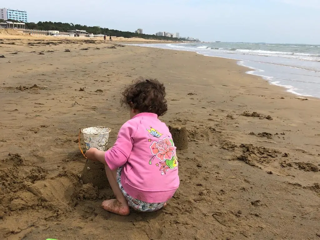 Una bimba gioca in spiaggia a Lignano
