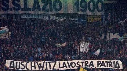 FILE - In this Nov. 29, 1998 file photo, Lazio fans display banners from the stands reading "Auschwitz is Your Homeland. The Ovens are Your Homes" during a Serie A match between Lazio and AS Roma, at Rome's Olympic stadium. Lazio fans have a long history of racism and anti-Semitism but the Roman club's supporters established a new low on Sunday, Oct. 22, 2017 when they littered the Stadio Olimpico with superimposed images of Anne Frank _ the young diarist who died in the Holocaust _ wearing a Roma jersey. (ANSA/AP Photo/Plinio Lepri, files) [CopyrightNotice: AP1998]