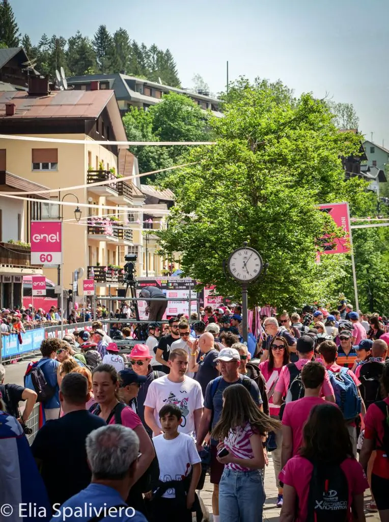 Splende il sole, intanto, in Friuli. Finalmente bel tempo sul Giro inseguito per giorni e giorni dalla pioggia nella sua risalita al Nord; spettacolo fino all’ultimo per una classifica apertissima come non mai. Tantissime le persone sulle strade, a Tarvisio e al Santuario, che applaudono i ciclisti ma soprattutto i due atleti friulani in gara, Alessandro De Marchi e Jonathan Milan, con la sua maglia ciclamino semplicemente passato in 21 tappe da esordiente a eroe acclamato da tutti e protagonista ieri dell’impresa del Giro arrivando in tempo massimo dopo una notte insonne. E poi turisti-tifosi in arrivo da Austria, soprattutto Slovenia per il loro Roglic; telespettatori incollati alle tv da tutto il mondo per assistere al debutto della misteriosa salita del Lussari, musica per le orecchie della Regione (Foto Petrussi)