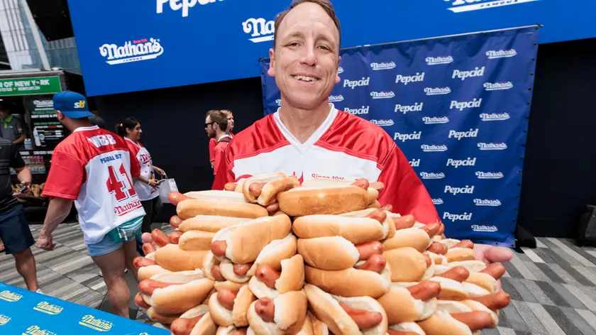 epa10724535 Top-ranked competitive eater Joey Chestnut holds a plate of 76 hot dogs, the record number he has eaten, during a weigh-in ceremony for Nathan's Famous Fourth of July International Hot Dog Eating Contest in New York, New York, USA, 03 July 2023. The annual eating contest will be held tomorrow in the Coney Island neighborhood of Brooklyn, New York. EPA/JUSTIN LANE