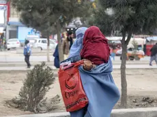 epa11324546 A burqa clad Afghan woman carries a child on a road in Kabul Afghanistan, 07 May 2024. Australia announced on 03 May it had committed to offering aid of AUD 492 million (USD 323 million) to reduce poverty in countries of the Indo-Pacific region through a fund from the Asian Development Bank. Australia has defended placing emphasis on mitigating the effects of the climate crisis and on the inclusion of new mechanisms to ensure the arrival of aid to people in Afghanistan, Myanmar and the Rohingya ethnic minority displaced in Bangladesh, with special emphasis on women and girls. EPA/SAMIULLAH POPAL