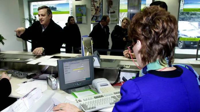 Un'impiegata ad uno sportello bancario in una foto d'archivio. ANSA / ALESSIA PARADISI