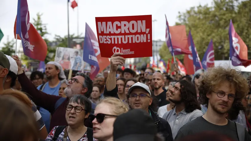 epa11591122 People attend a protest rally in Paris, France, 07 September 2024 as the French left parties called for rallies against President Macron's politics. Protests are taking place across France over the appointment of Michel Barnier as the new French prime minister, after the election that resulted in a National Assembly without a majority and in which the left won the largest number of seats. The poster reads "Macron destitution''. EPA/YOAN VALAT