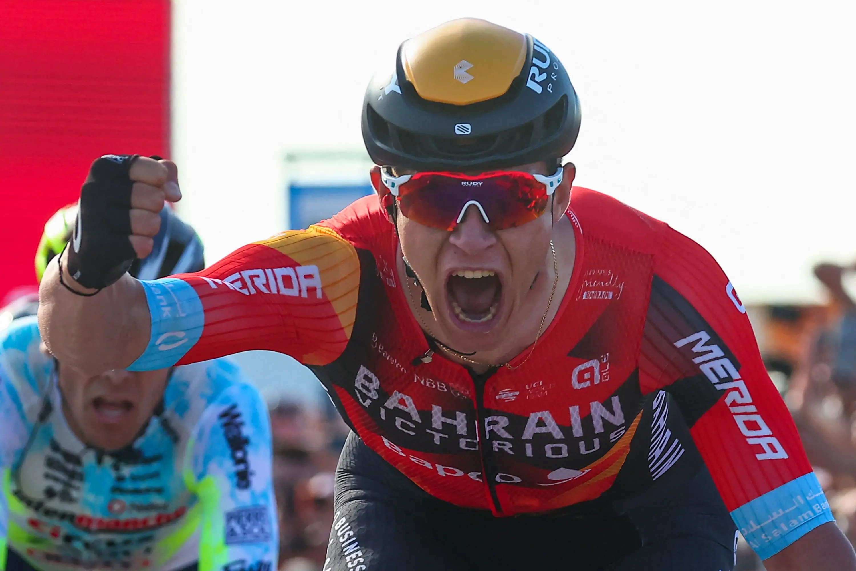 Bahrain - Victorious's Italian rider Jonathan Milan (C) celebrates as he crosses the finish line to win the second stage of the Giro d'Italia 2023 cycling race, 202 km between Teramo and San Salvo, on May 7, 2023. (Photo by Luca Bettini / AFP)