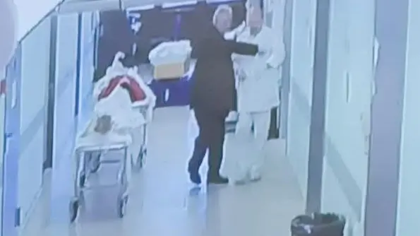Il titolare di una impresa funebre mette i soldi nel taschino di un addetto che (sotto) porta i soldi in spogliatoio