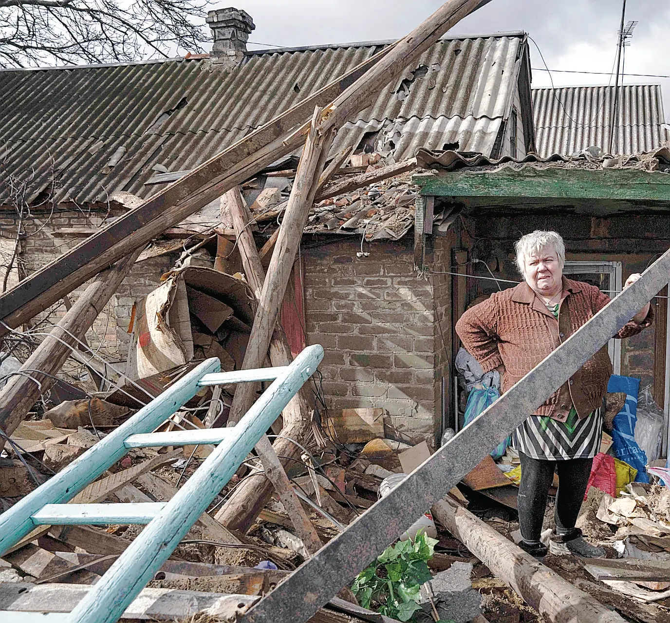 Olena Lysovska checks her house that was destroyed by a Russian rocket in Maxymilianivka village, Ukraine, Tuesday, Feb. 21, 2023. (AP Photo/Evgeniy Maloletka)