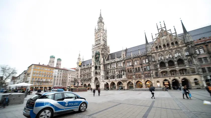 epa08301137 A police car drives in front of the city hall across the Marienplatz in the centre of Munich, Bavaria, Germany, 17 March 2020. The German government and local authorities are heightening measures to stem the spread of the coronavirus SARS-CoV-2 which causes the COVID-19 disease. According to the disease control centre of the Robert Koch Institute, the number of coronavirus COVID-19 cases in Germany has exceeded the 7,500 mark on Tuesday morning 17 March 2020. EPA/LUKAS BARTH-TUTTAS