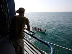 epa11014311 A boat carries people as a Houthi fighter keeps watch on the deck of the Galaxy Leader cargo ship, seized by the Houthis offshore of the Al-Salif port on the Red Sea in the province of Hodeidah, Yemen, 05 December 2023 (issued 06 December 2023). Yemen's Houthis on 06 December 2023 claimed responsibility for the launch of the barrage of ballistic missiles toward Israel in support of the Palestinian people in the Gaza Strip, according to a statement by Houthis spokesman Yahya Saree. The Houthis vowed to continue their efforts to prevent Israeli ships from navigating in the Arabian and Red Seas, in retaliation for Israel's airstrikes on the Gaza Strip. Thousands of Israelis and Palestinians have died since the militant group Hamas launched an unprecedented attack on Israel from the Gaza Strip on 07 October, and the Israeli strikes on the Palestinian enclave which followed it. EPA/YAHYA ARHAB