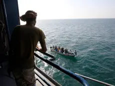 epa11014311 A boat carries people as a Houthi fighter keeps watch on the deck of the Galaxy Leader cargo ship, seized by the Houthis offshore of the Al-Salif port on the Red Sea in the province of Hodeidah, Yemen, 05 December 2023 (issued 06 December 2023). Yemen's Houthis on 06 December 2023 claimed responsibility for the launch of the barrage of ballistic missiles toward Israel in support of the Palestinian people in the Gaza Strip, according to a statement by Houthis spokesman Yahya Saree. The Houthis vowed to continue their efforts to prevent Israeli ships from navigating in the Arabian and Red Seas, in retaliation for Israel's airstrikes on the Gaza Strip. Thousands of Israelis and Palestinians have died since the militant group Hamas launched an unprecedented attack on Israel from the Gaza Strip on 07 October, and the Israeli strikes on the Palestinian enclave which followed it. EPA/YAHYA ARHAB