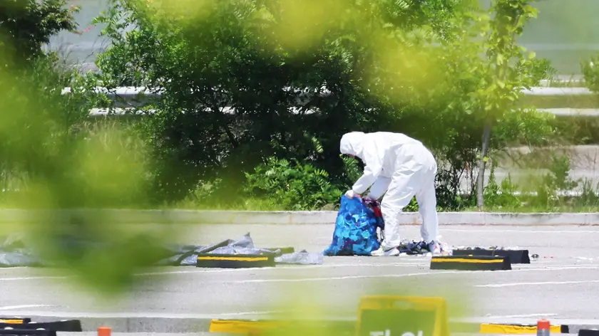 epa11385075 An official collects the debris of a balloon sent by North Korea at a shopping center in Siheung, west of Seoul, South Korea, 02 June 2024. EPA/YONHAP SOUTH KOREA OUT