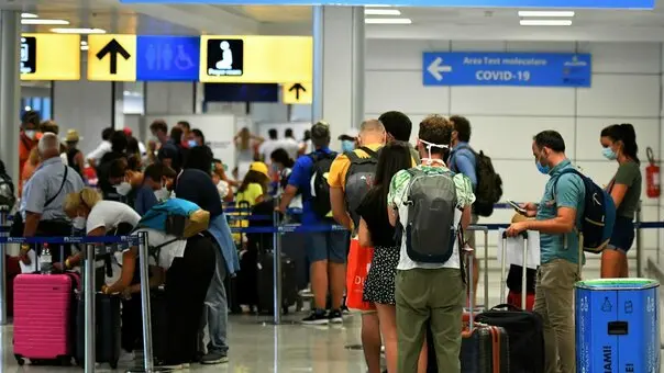 Passengers queue to be screened for Covid-19 at a testing station set up at Fiumicino airport, near Rome, on August 16, 2020. - Italy has introduced mandatory Covid-19 (novel coronavirus) testing for anyone arriving from Croatia, Greece, Spain and Malta and banned all visitors from Colombia, in a bid to rein in new infections. (Photo by Alberto PIZZOLI / AFP)