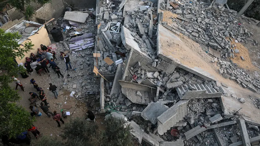 epa10628563 Palestinians from the Abu-Nabhan family gather near the rubble of their destroyed family house, following Israeli strikes in Jabaliya town, northern Gaza Strip, 14 May 2023. Israel and Islamic Jihad movement agreed to an Egyptian-brokered truce late 14 May. Israel has carried out several attacks against the military leadership of the Palestinian Islamic Jihad movement, in retaliation to rockets being fired towards Israel from in the Gaza Strip. EPA/MOHAMMED SABER