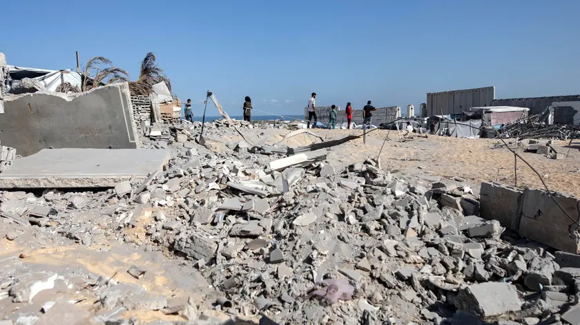 epa11613395 Internally displaced Palestinians stand amidst the rubble as they inspect the damage on their tents following an overnight Israeli strike in the vicinity of the humanitarian area of Al-Mawasi, west of Khan Younis, southern Gaza Strip, 19 September 2024. More than 41,000 Palestinians and over 1,400 Israelis have been killed, according to the Palestinian Health Ministry and the Israel Defense Forces (IDF), since Hamas militants launched an attack against Israel from the Gaza Strip on 07 October 2023, and the Israeli operations in Gaza and the West Bank which followed it. EPA/HAITHAM IMAD