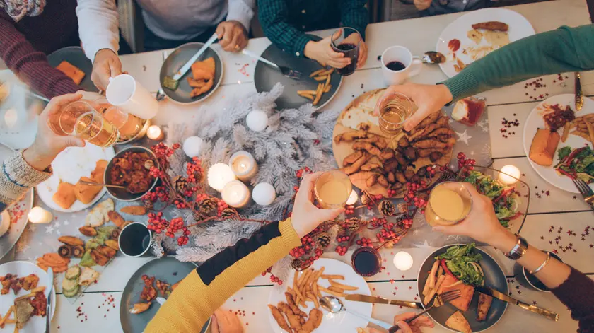 Photo of a multi generation family during Thanksgiving dinner, spending time together over eaten food and messy plates